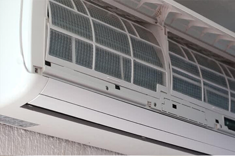 An air conditioner with front cover flipped up.